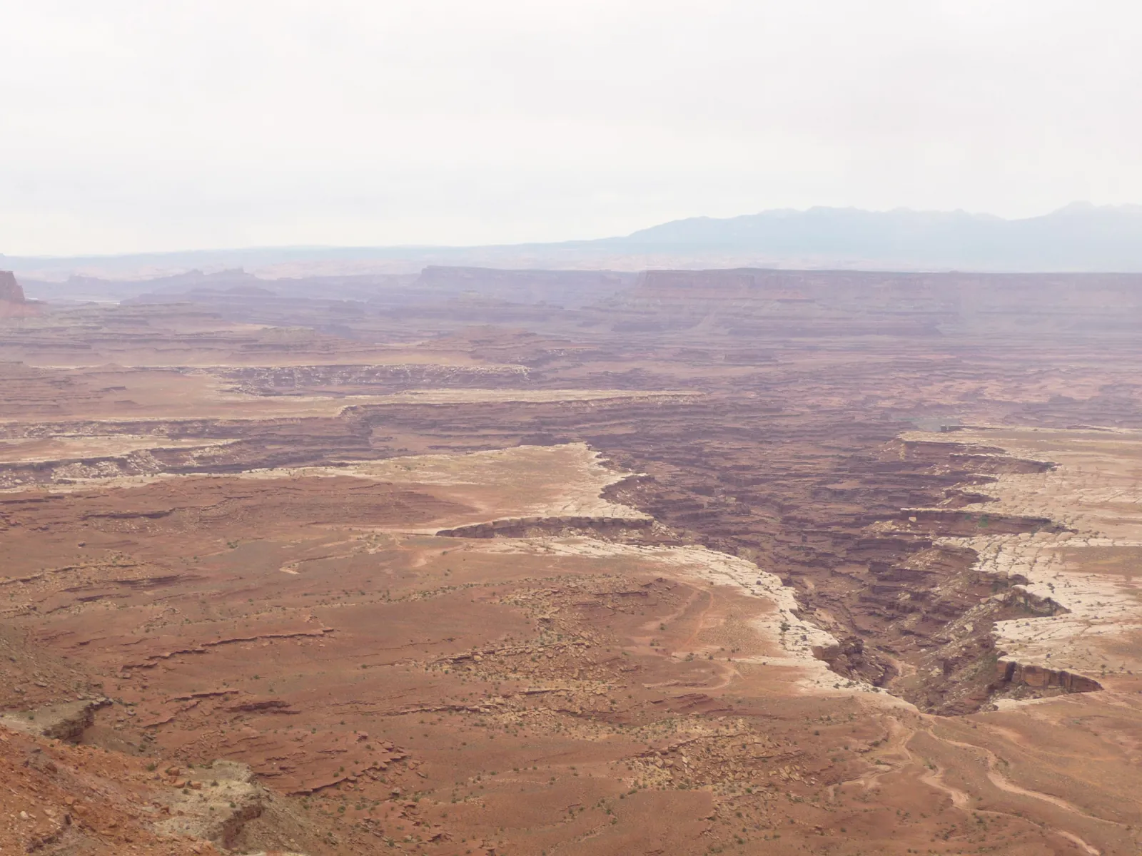 Le canyon et ses paliers de roche, avec des montagnes à l'horizon
